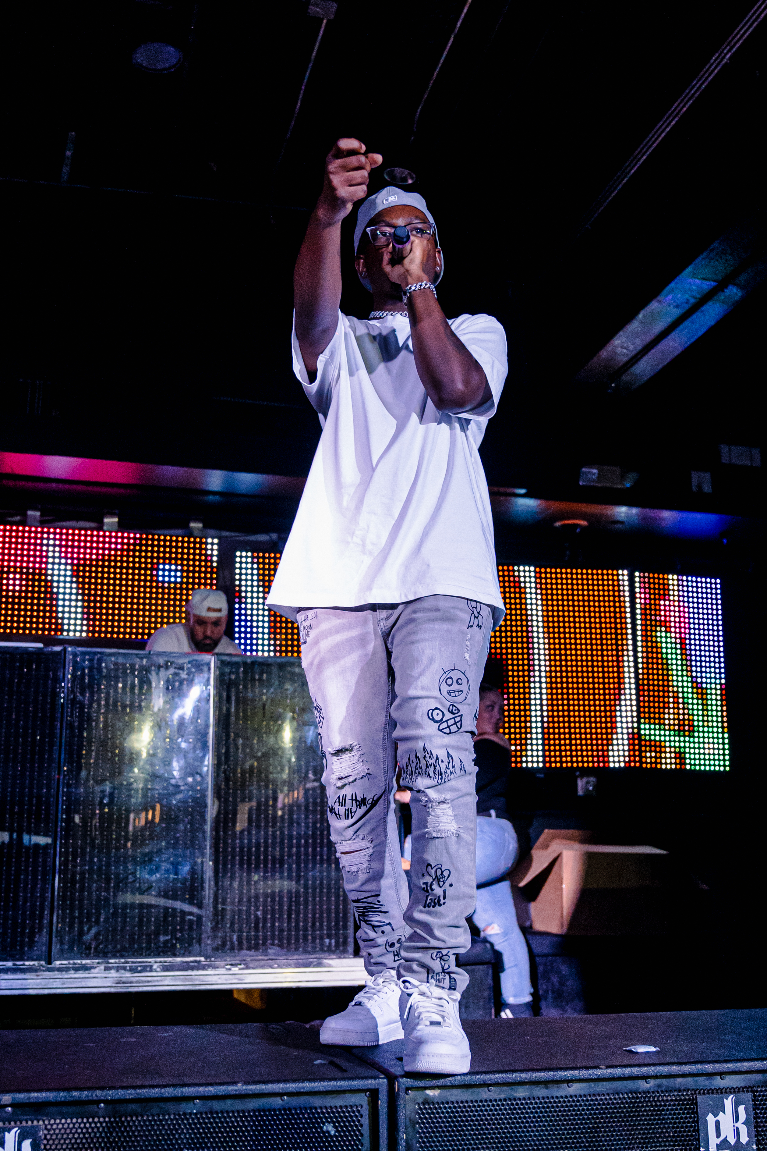 KWEZZ performing with a microphone and one arm raised